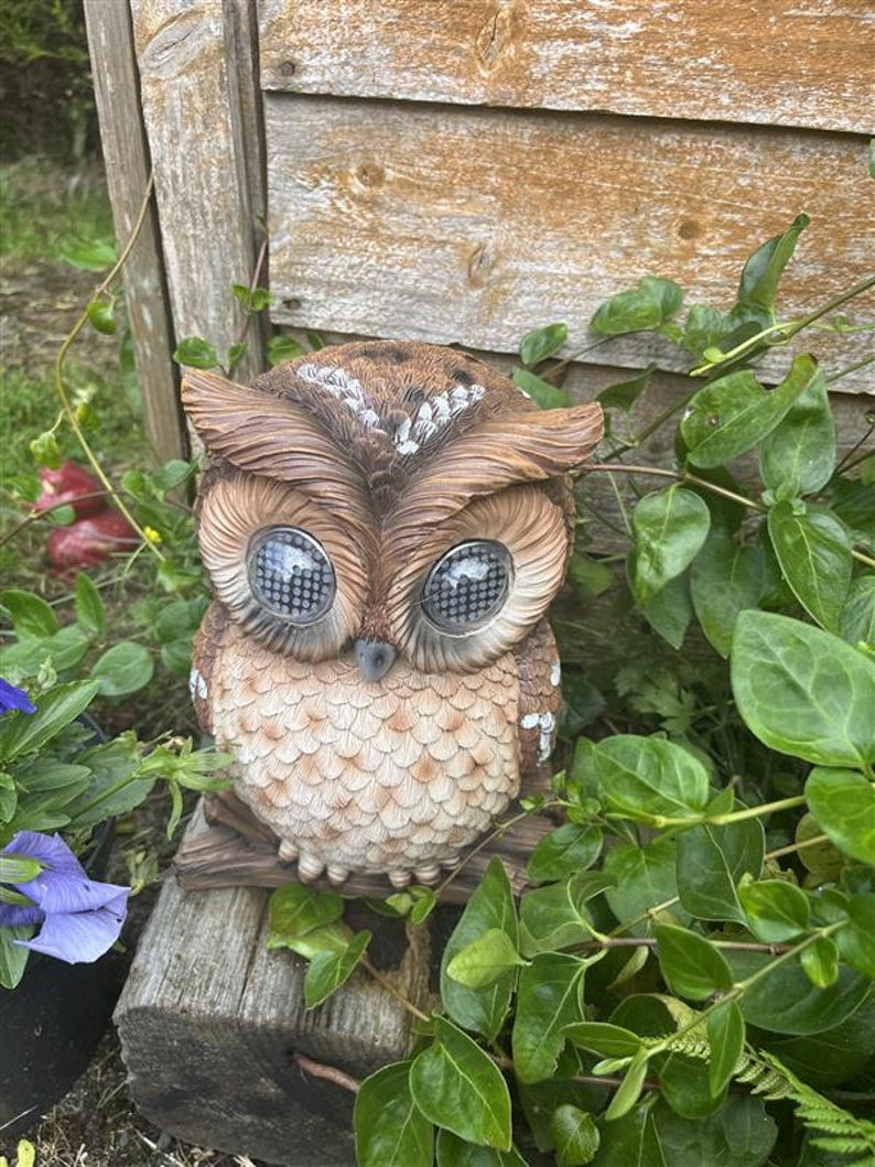 Solar-powered owl winking illuminated sculpture